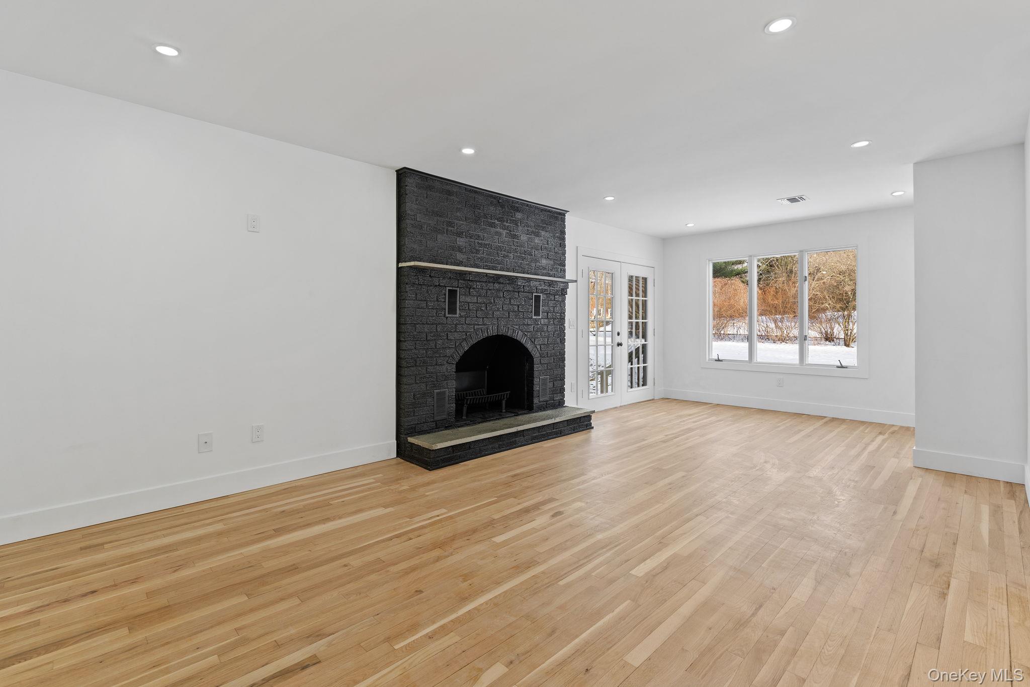 52 Rudolph Road Modena, NY 12548 - Photo 23 of 46 Unfurnished living room with light wood finished floors, french doors, a fireplace, and recessed lighting