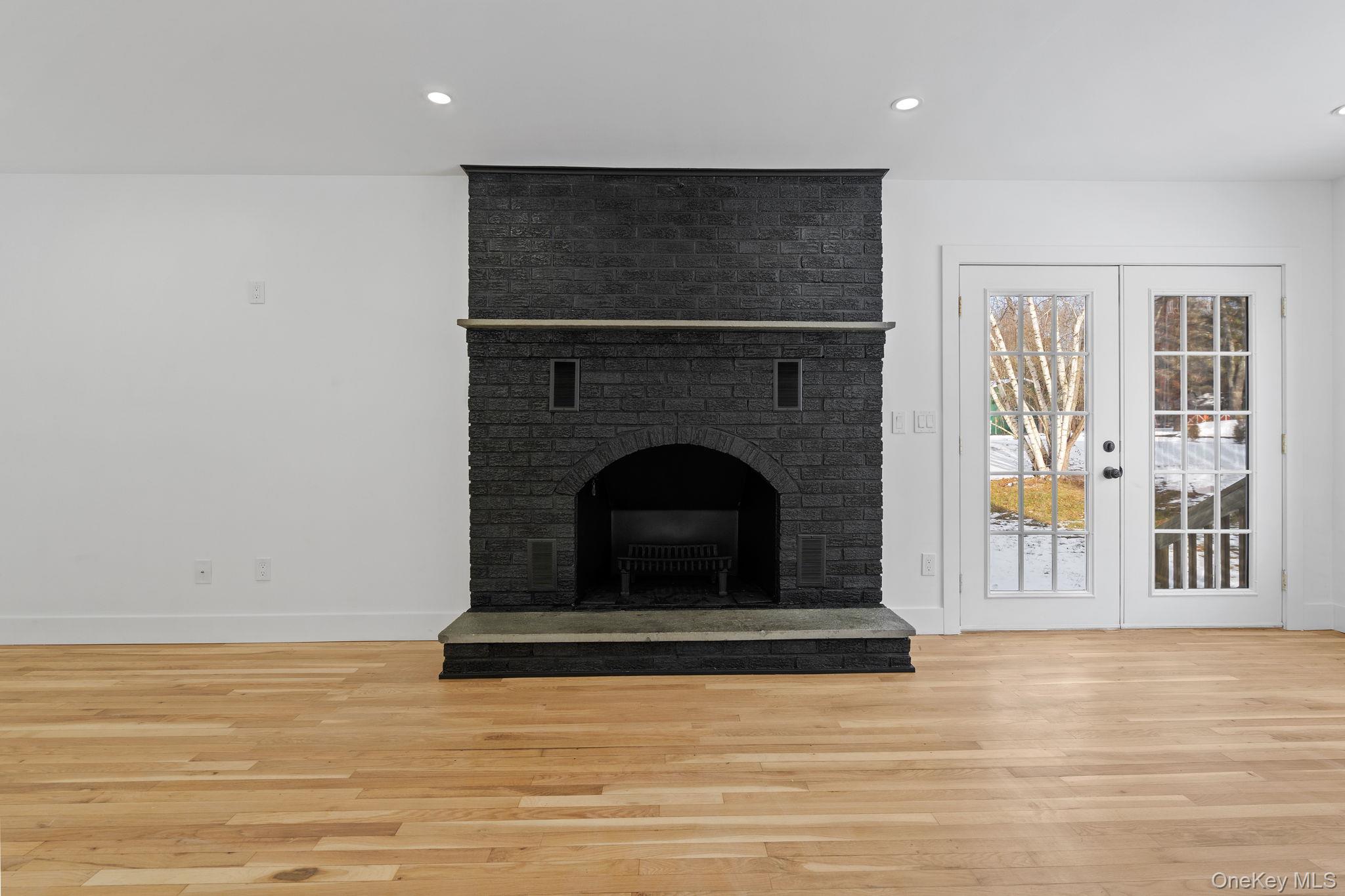 52 Rudolph Road Modena, NY 12548 - Photo 24 of 46 Unfurnished living room featuring light wood finished floors, recessed lighting, a brick fireplace, and french doors