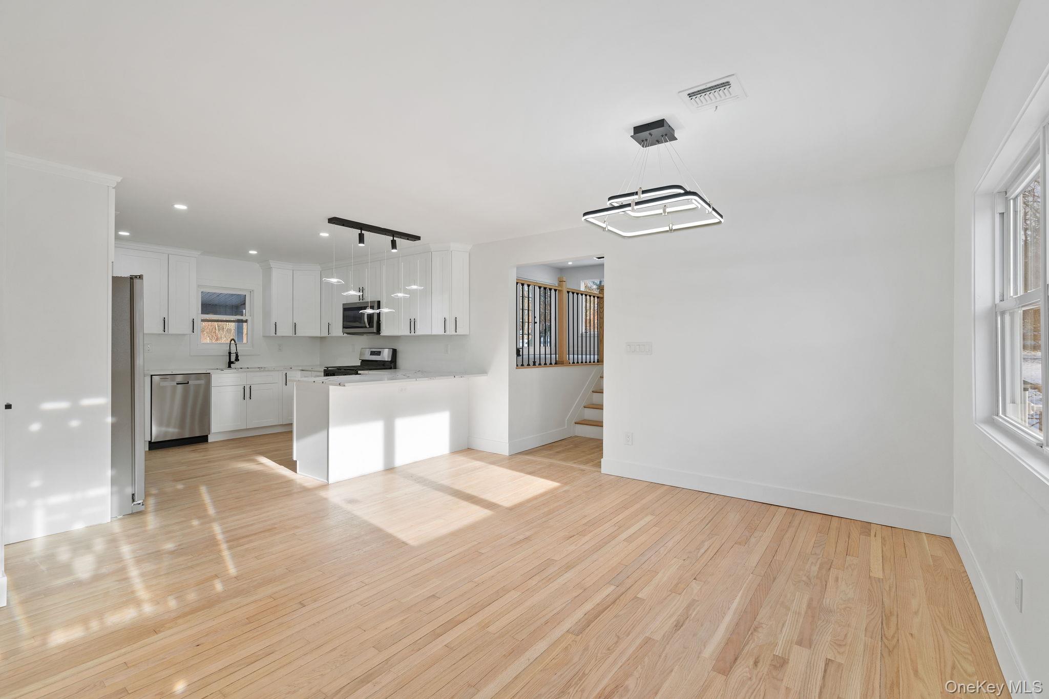 52 Rudolph Road Modena, NY 12548 - Photo 4 of 46 Unfurnished living room featuring light wood-type flooring, recessed lighting, and stairs
