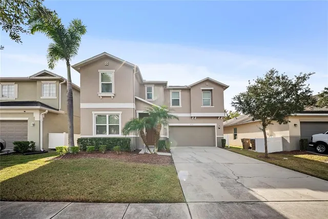 a front view of a house with a yard and a garage