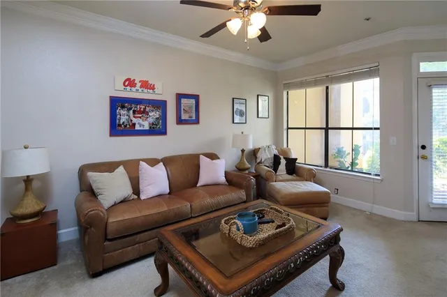 a living room with furniture a chandelier and a window
