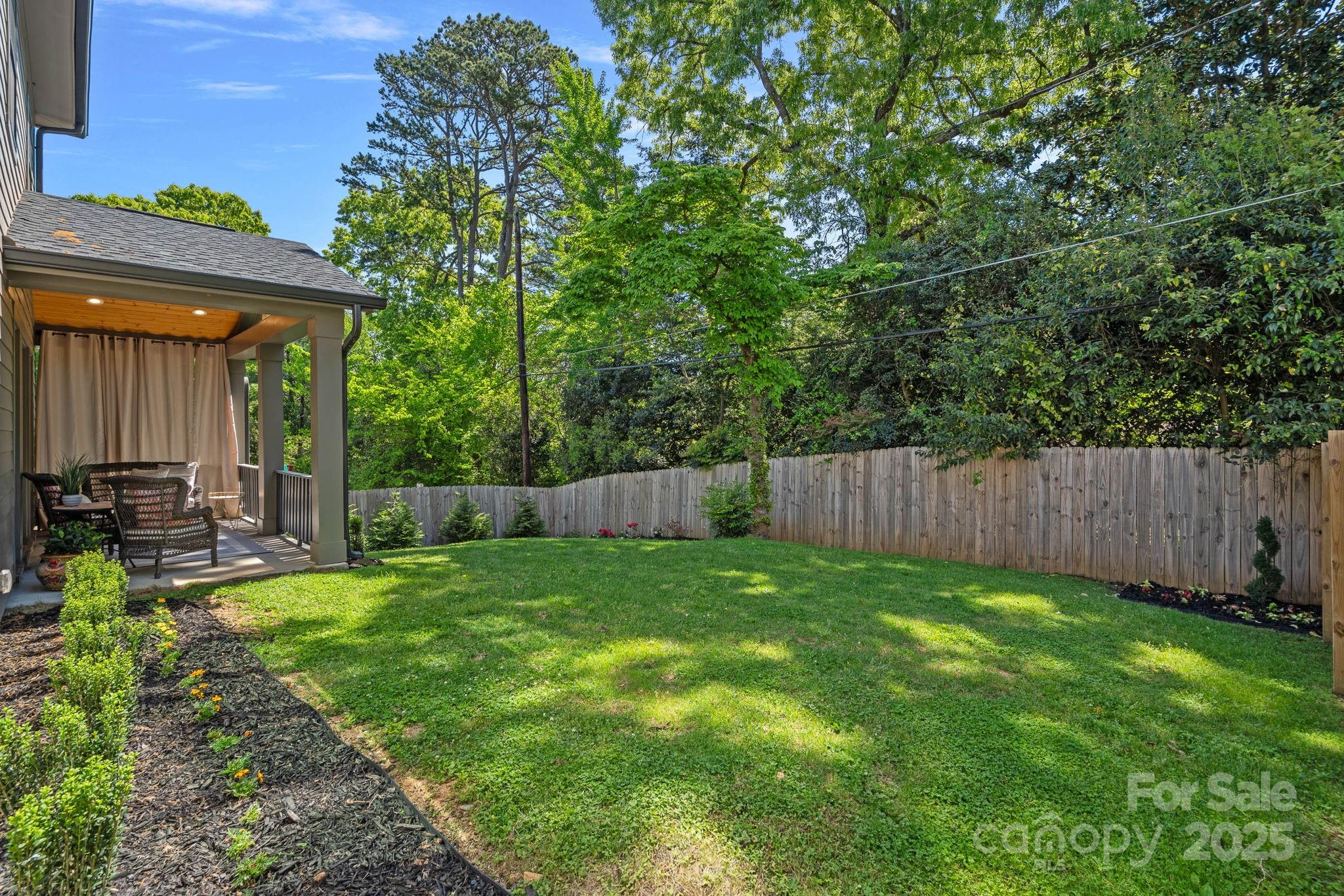 3228 East Ford Road Charlotte, NC 28205 - Photo 29 of 31 a view of a backyard with table and chairs and wooden fence