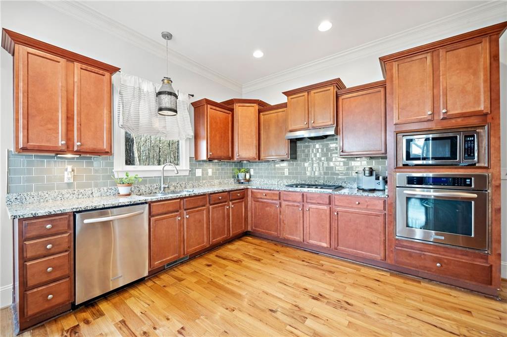 121 Moose Loop Waleska, GA 30183 - Photo 24 of 57 a kitchen with stainless steel appliances granite countertop a stove sink and cabinets