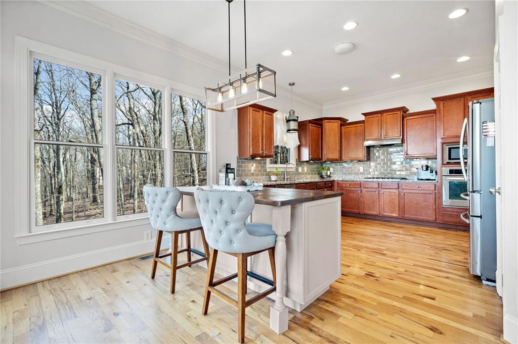 121 Moose Loop Waleska, GA 30183 - Photo 26 of 57 a kitchen with stainless steel appliances granite countertop dining table chairs wooden cabinets and a window