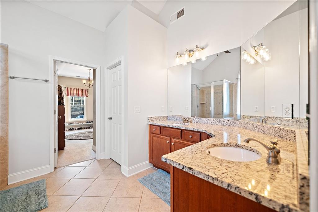 121 Moose Loop Waleska, GA 30183 - Photo 34 of 57 a bathroom with a granite countertop sink a mirror and shower
