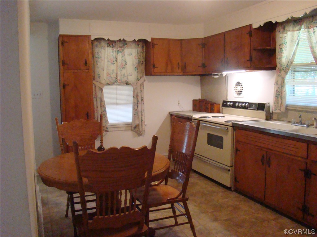 15320 Harrowgate Road Chester, VA 23831 - Photo 11 of 28 a kitchen with a dining table chairs and a refrigerator