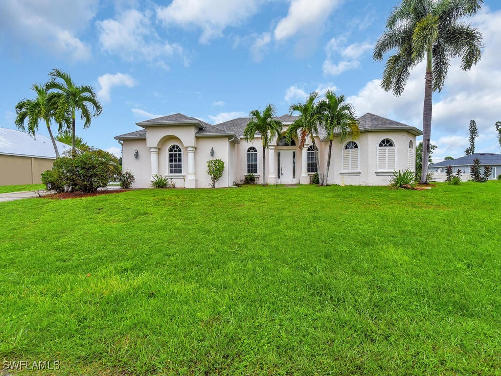 8123 Sandpiper Road Fort Myers, FL 33967 - Photo 1 of 23 a front view of a house with a garden and trees