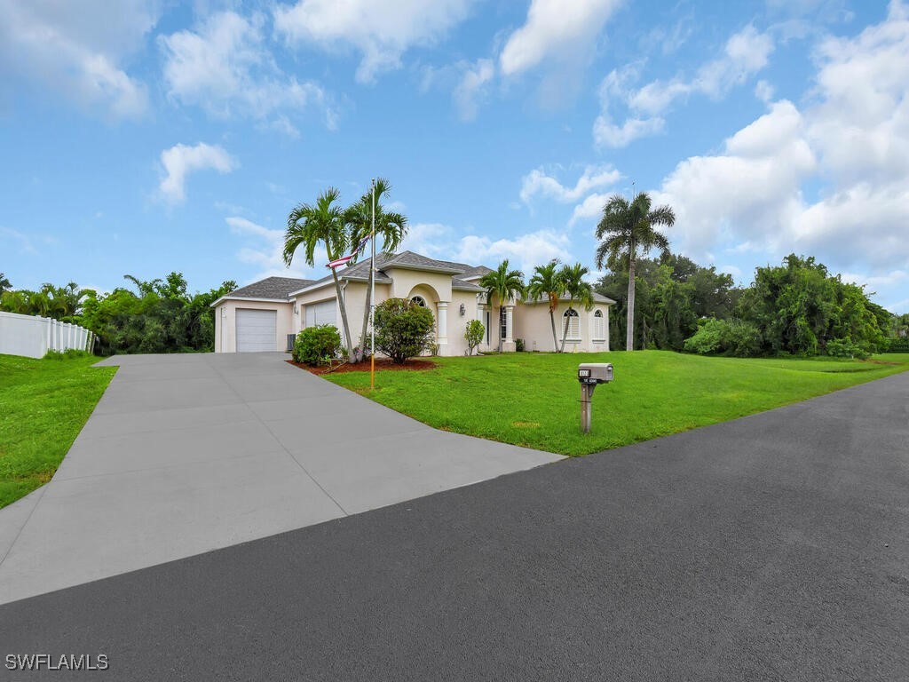 8123 Sandpiper Road Fort Myers, FL 33967 - Photo 2 of 23 a view of a white house with a big yard and palm trees