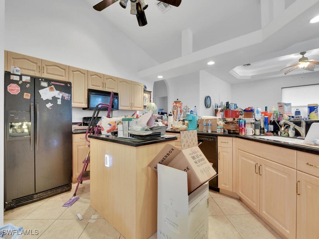 8123 Sandpiper Road Fort Myers, FL 33967 - Photo 6 of 23 a kitchen filled with stainless steel appliances kitchen island granite countertop a refrigerator and microwave