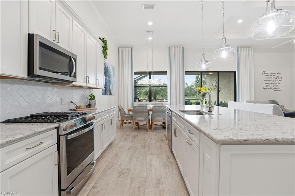 17210 Ashcomb Way Estero, FL 33928 - Photo 12 of 47 a kitchen with stainless steel appliances granite countertop a stove a sink and a microwave