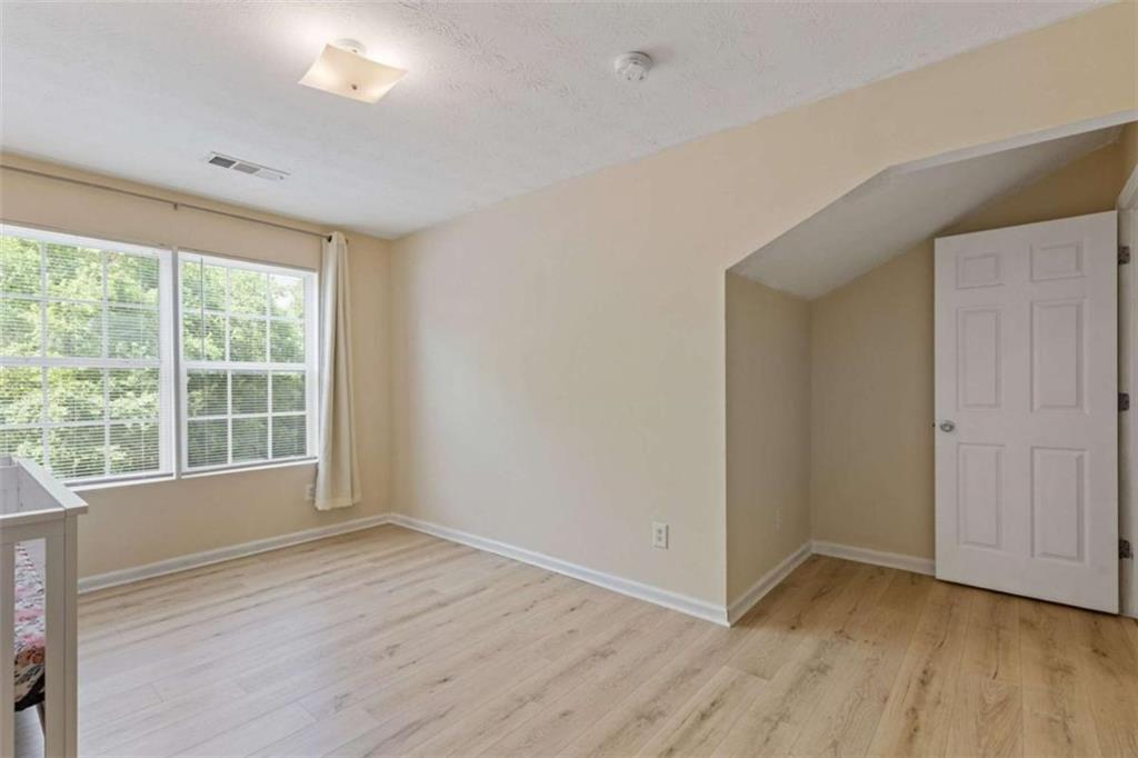 1450 Steam Engine Way Northeast Conyers, GA 30013 - Photo 16 of 33 a view of an empty room with wooden floor and a window