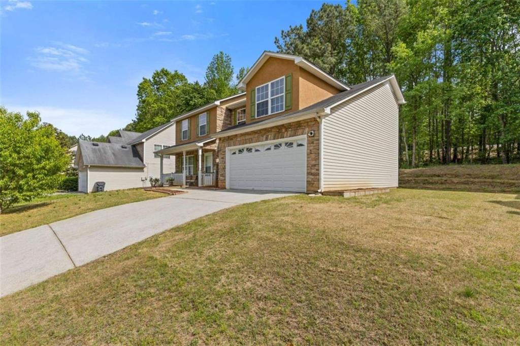 1450 Steam Engine Way Northeast Conyers, GA 30013 - Photo 3 of 33 a front view of a house with a yard and garage