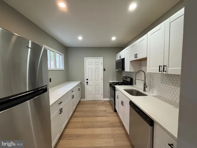 a large kitchen with stainless steel appliances sink a microwave and cabinets