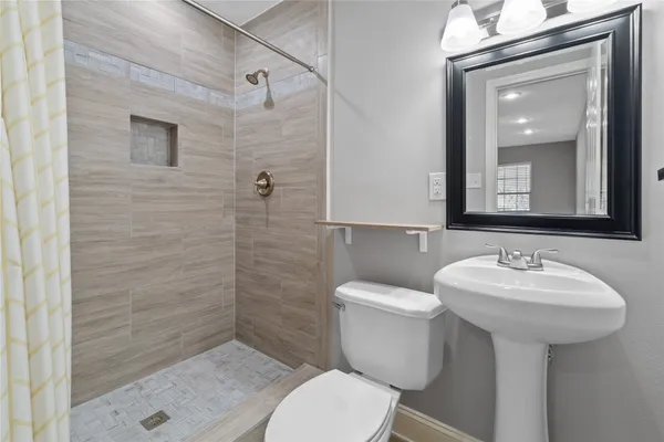 a bathroom with a sink toilet and mirror