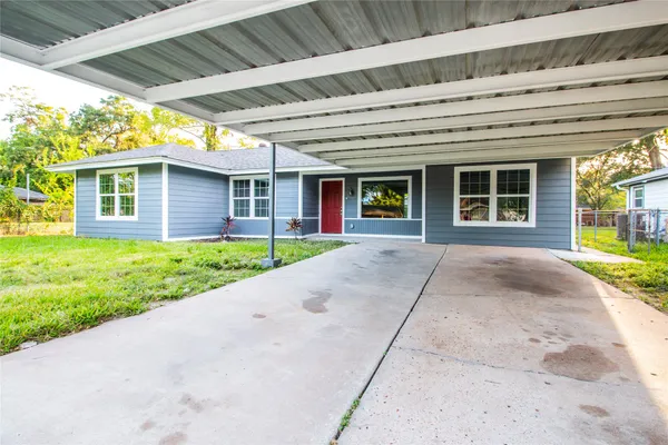 a view of a house with a yard and potted plants