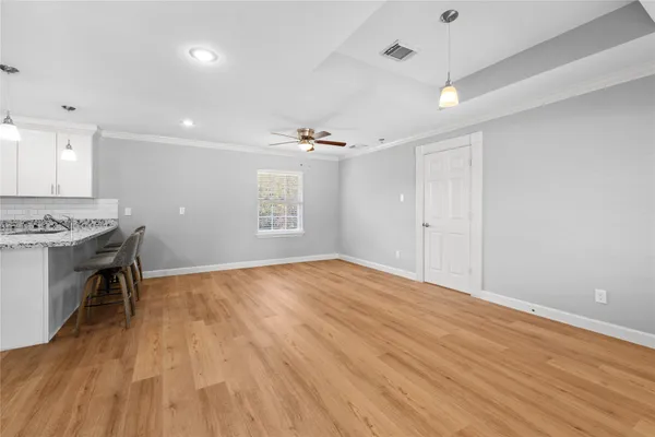 a view of an empty room with a window and wooden floor