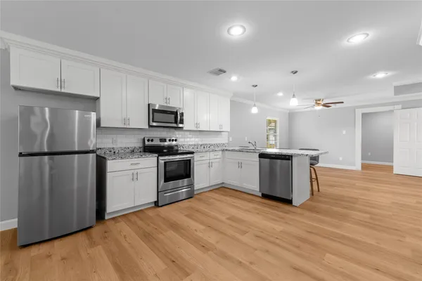 a kitchen with a refrigerator a stove top oven a sink and cabinets