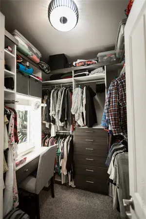 a view of walk in closet with clothes and shoes