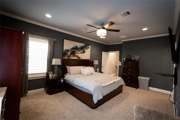 a spacious bedroom with a large bed and a chandelier