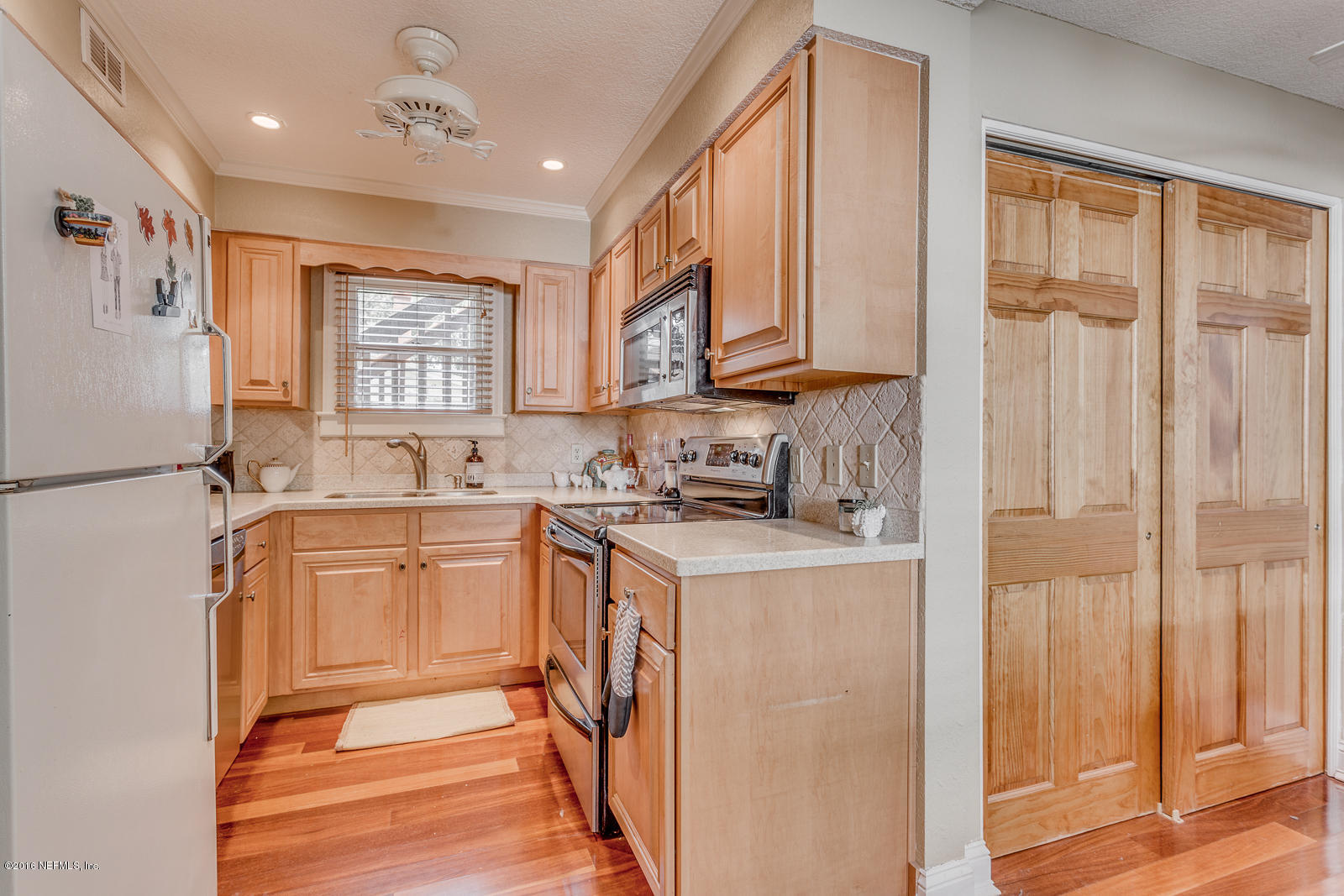 9 Riberia Street St. Augustine, FL 32084 - Photo 6 of 33 a kitchen with stainless steel appliances granite countertop a refrigerator a sink dishwasher and wooden cabinets with wooden floor