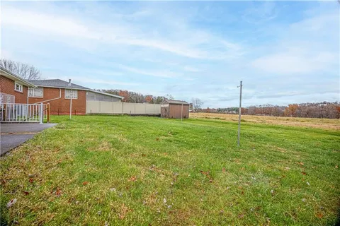 a view of a big yard with large trees