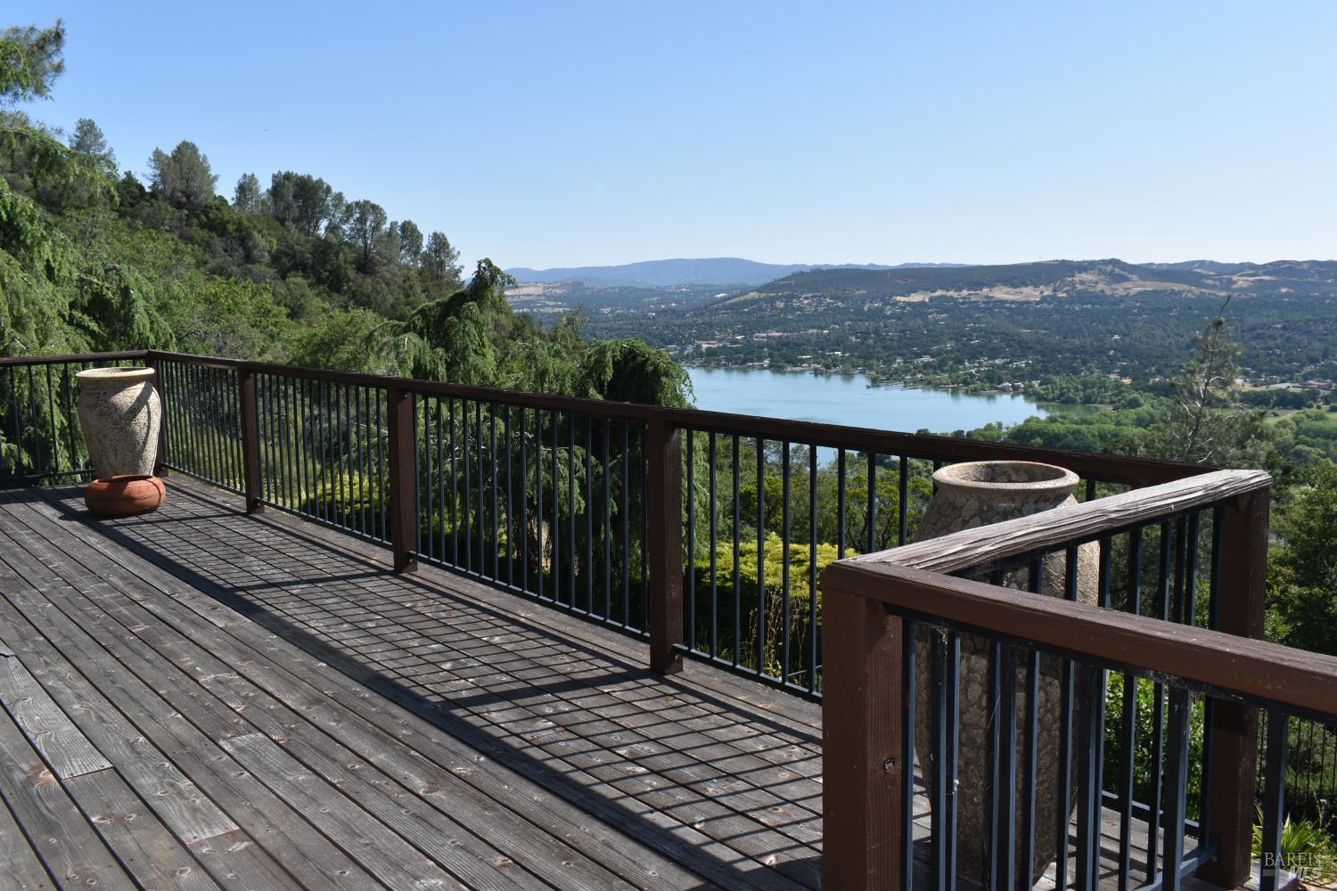 a view of a balcony with wooden floor and fence
