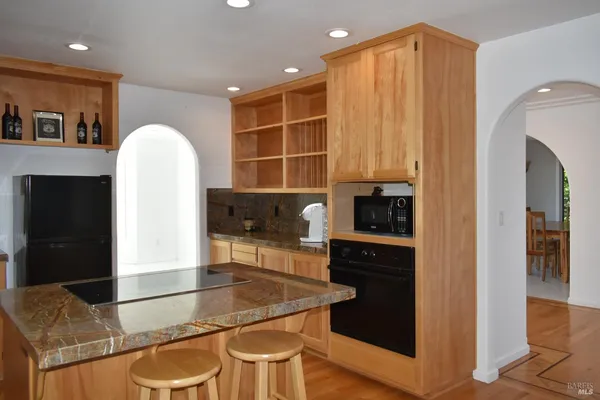 a kitchen with kitchen island a counter top space a sink a refrigerator and cabinets