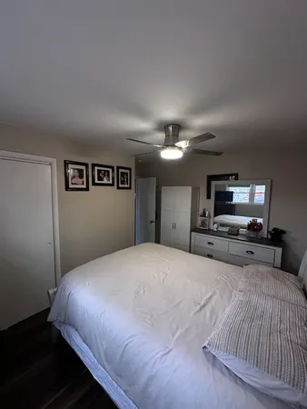 a bedroom with a large bed a flat tv screen and a chandelier