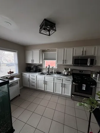 a kitchen with granite countertop a sink window and stainless steel appliances