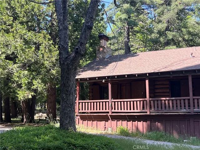 a view of a brick wall with plants and trees