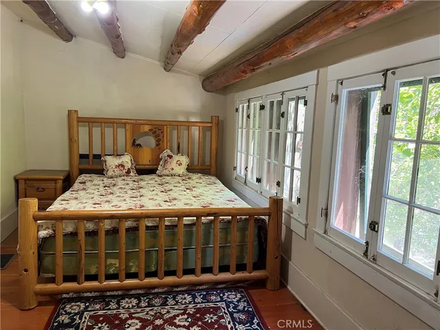 a large bed sitting in a bedroom next to a window