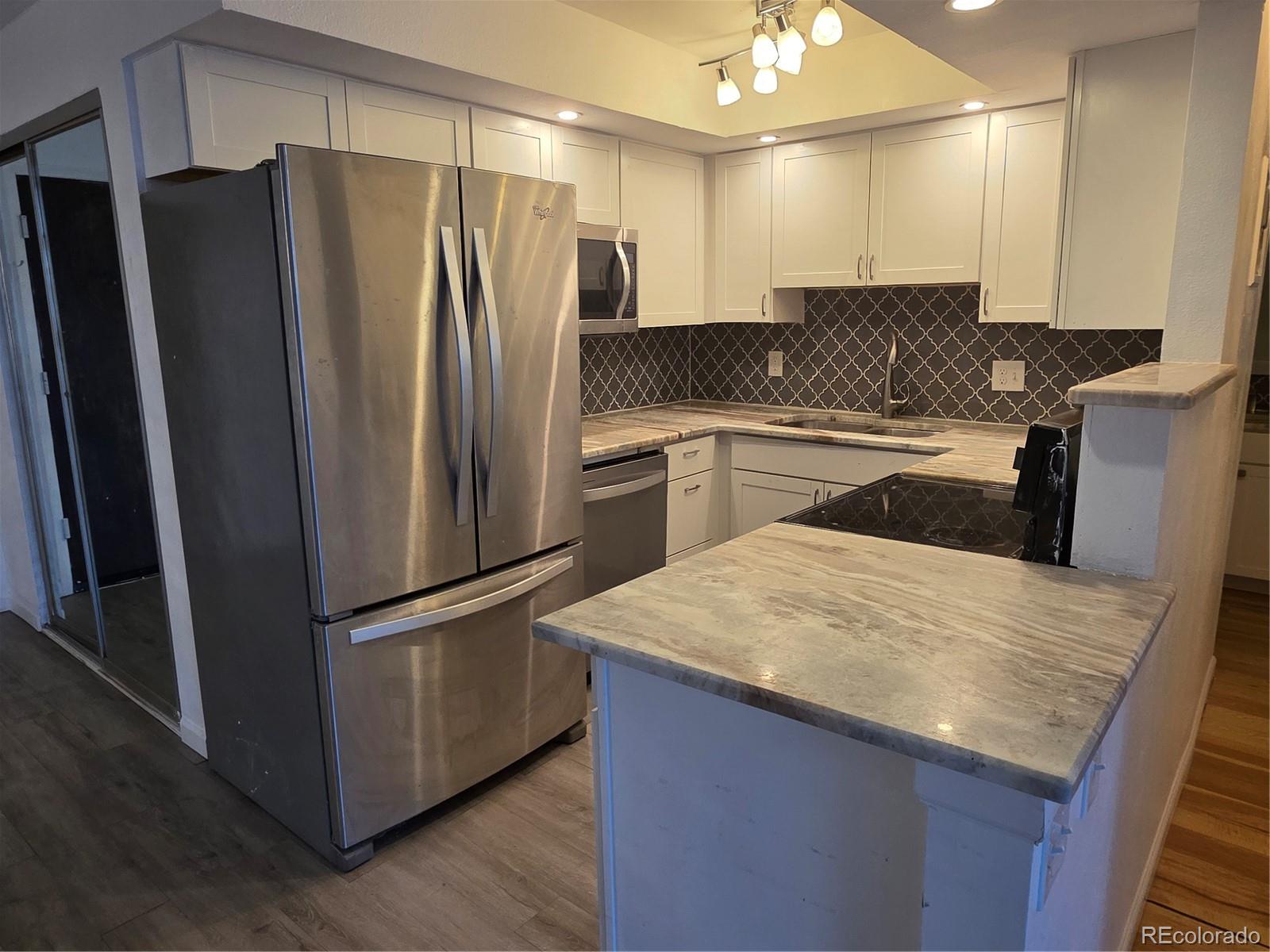 2 Adams Street, Unit 608 Denver, CO 80206 - Photo 5 of 18 a kitchen with granite countertop a refrigerator and a sink