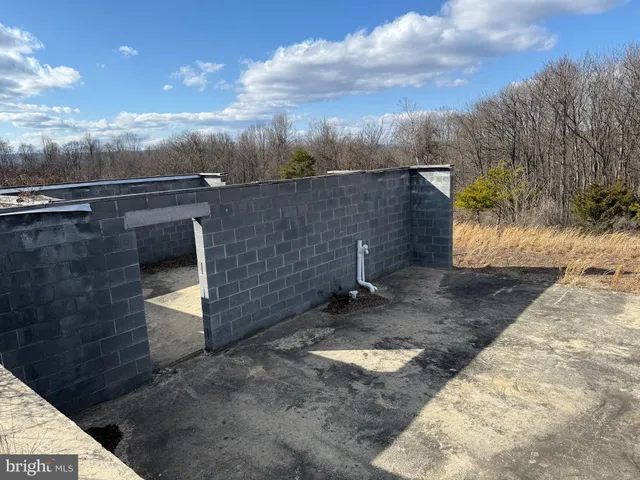 a view of a dry yard with wooden fence