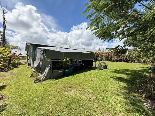 a vase of flowers sitting on a sidewalk