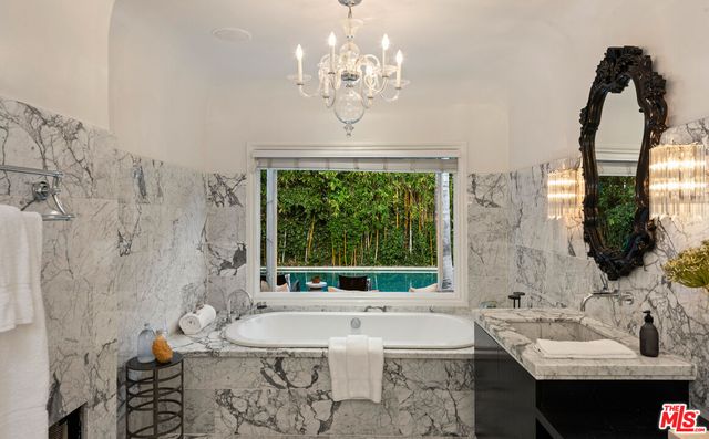 a bath room with a sink and a large mirror