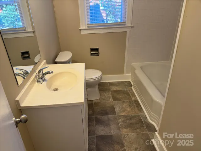 a bathroom with a sink and mirror with bathtub