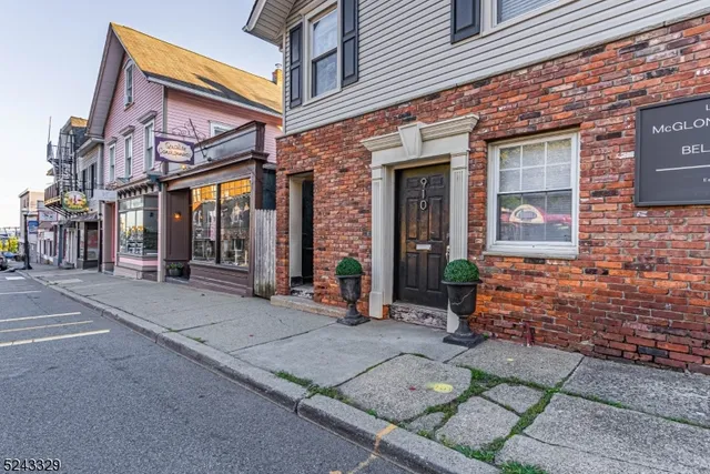 front view of a brick building with a bench in front