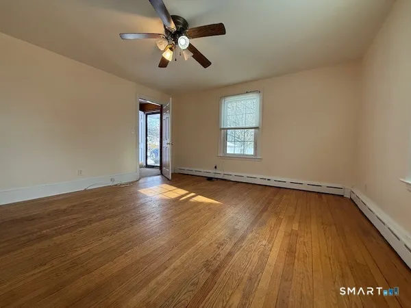 an empty room with wooden floor and windows