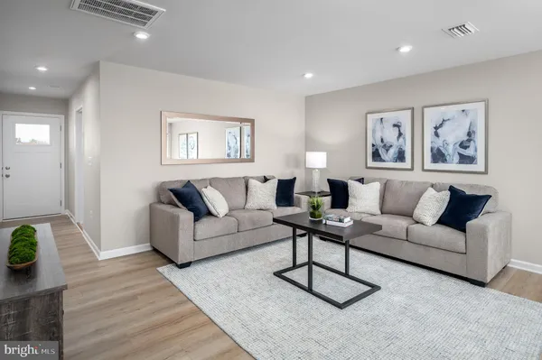 a living room with furniture a rug and a wooden floor