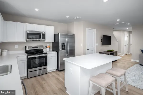 a kitchen with stainless steel appliances a stove top oven a refrigerator a sink and a stove