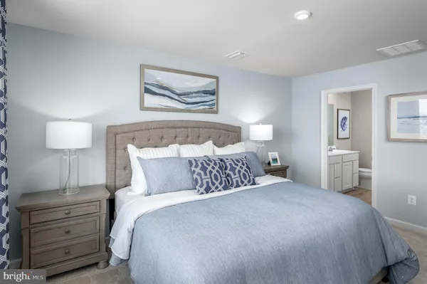 a bedroom with a bed and a painting on the wall