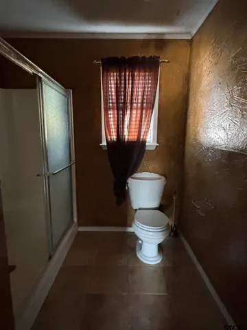 a white toilet sitting next to a window