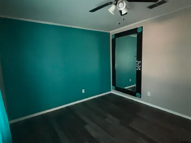 an empty room with a fan & a window