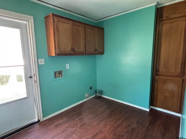 an empty room with wooden floor and window