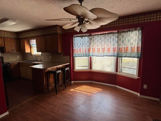 a kitchen with stainless steel appliances granite countertop a stove a sink and a microwave