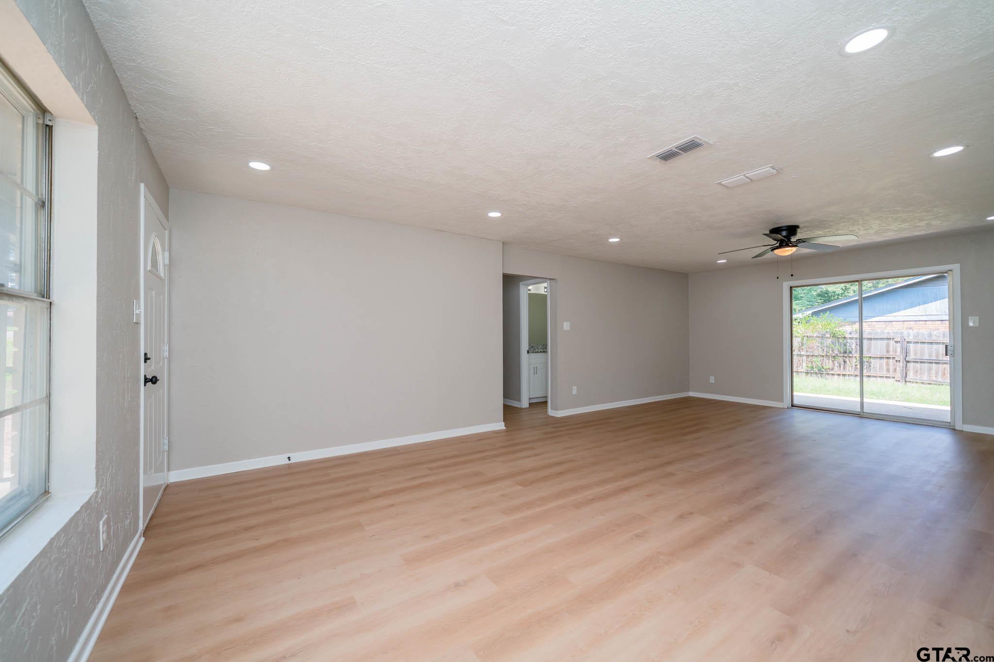 1411 Sapphire Street Longview, TX 75602 - Photo 11 of 38 a view of an empty room with wooden floor and a window