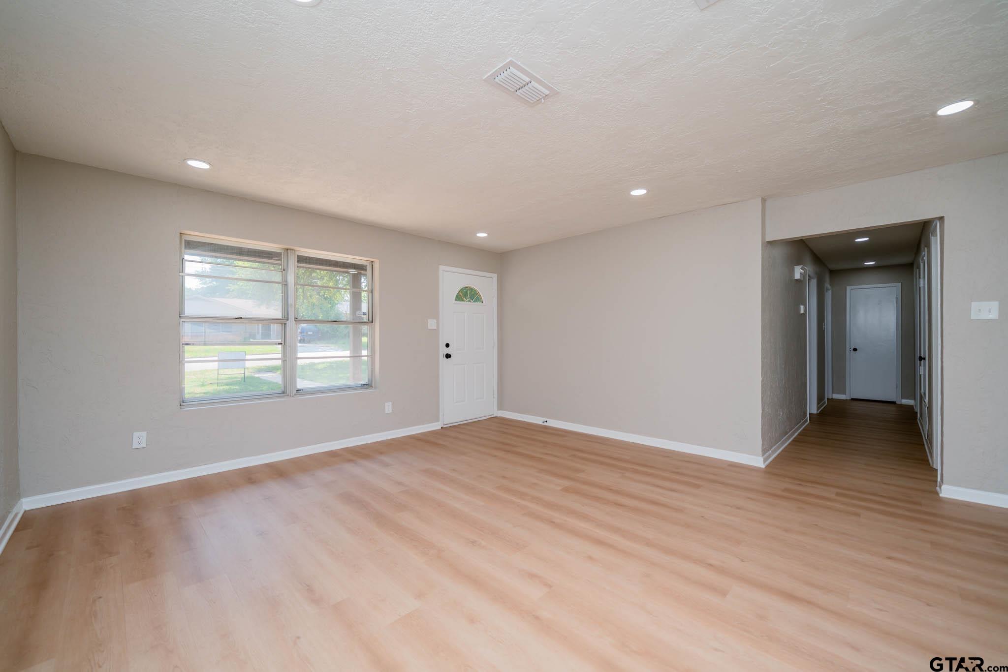 1411 Sapphire Street Longview, TX 75602 - Photo 12 of 38 a view of an empty room with wooden floor and a window