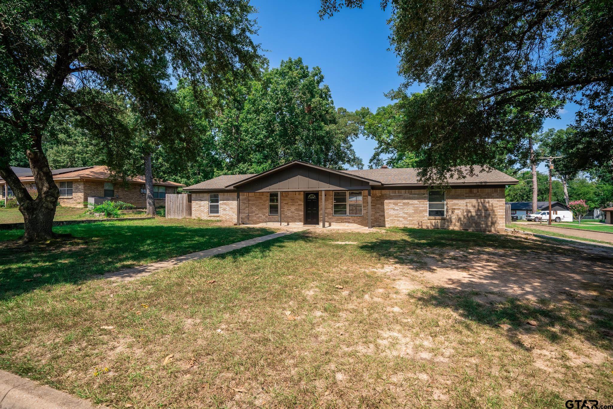 1411 Sapphire Street Longview, TX 75602 - Photo 2 of 38 a front view of a house with a yard and garage
