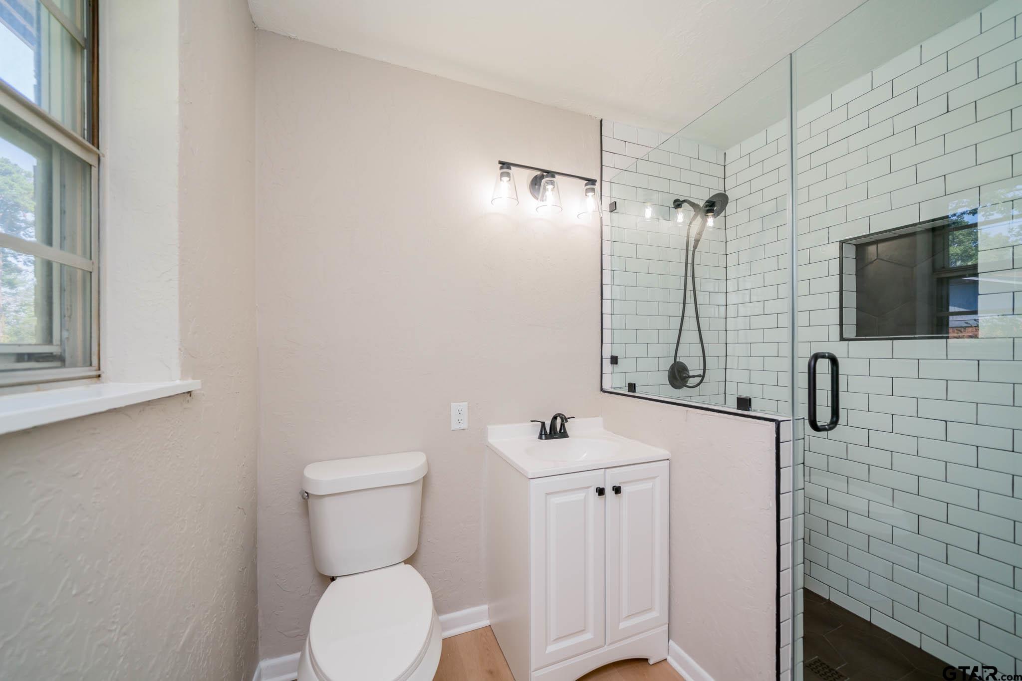 1411 Sapphire Street Longview, TX 75602 - Photo 25 of 38 a bathroom with a toilet sink and mirror