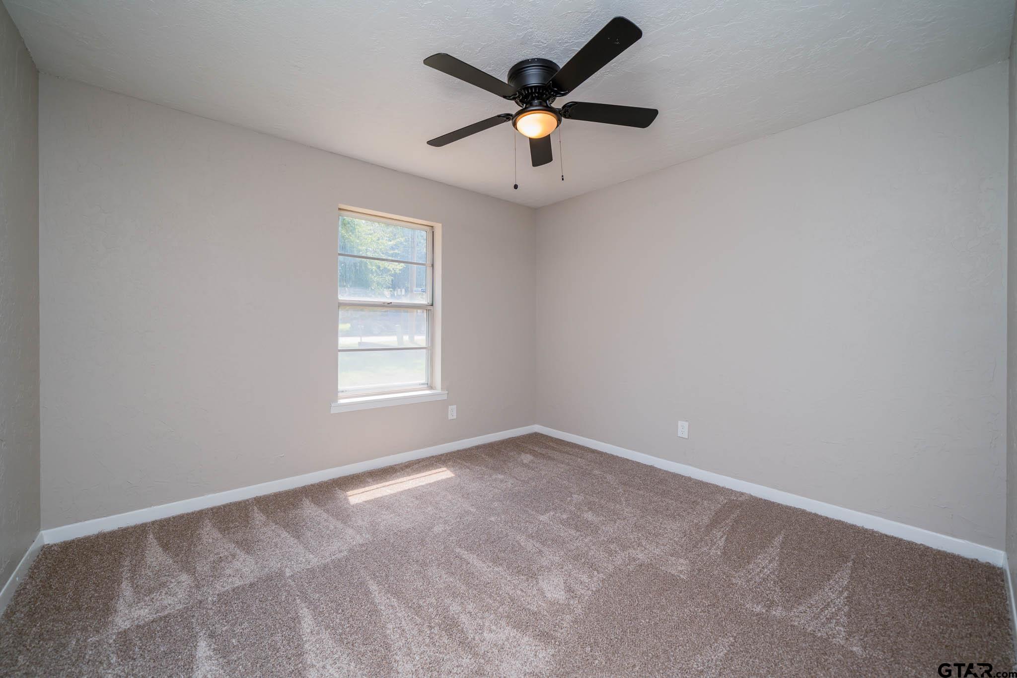 1411 Sapphire Street Longview, TX 75602 - Photo 26 of 38 an empty room with a window and a fan